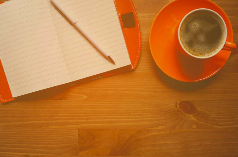 Tasse und Block auf Tisch