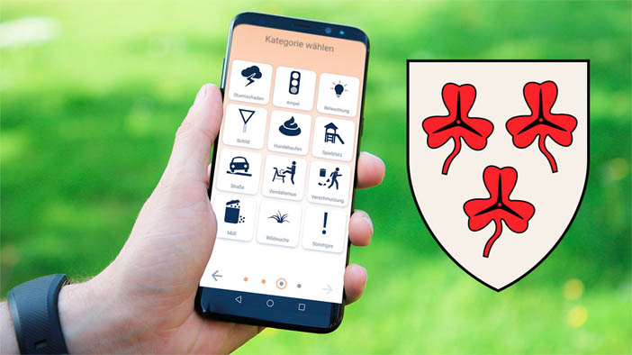 Handy mit Meldoo neben Wappen der Gemeinde Mettingen